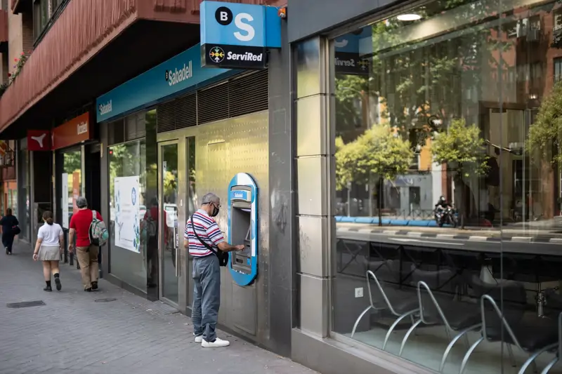 Un hombre saca dinero en un cajero de Sabadell