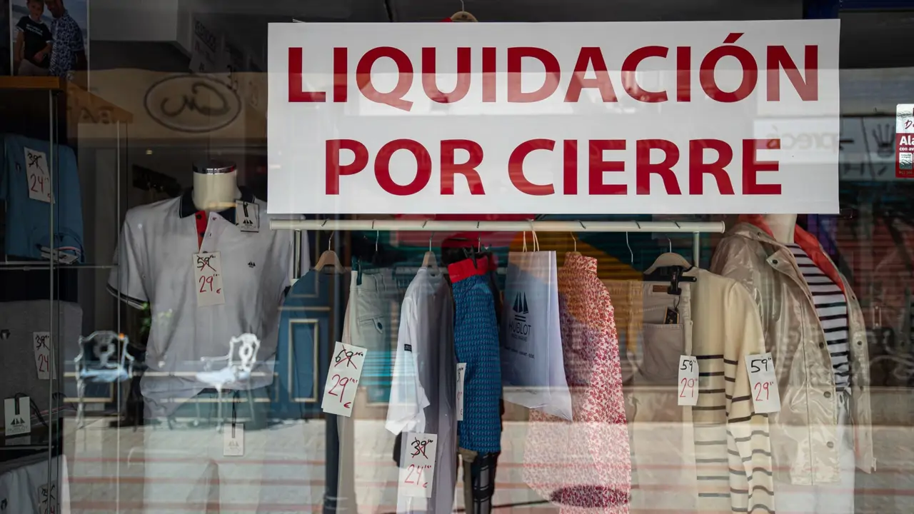 El escaparate de un comercio de ropa anuncia 'liquidación por cierre' en una calle de Palma de Mallorca