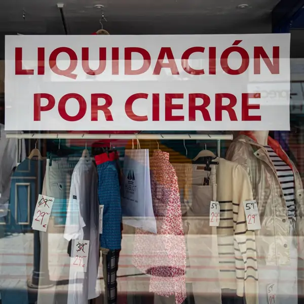 El escaparate de un comercio de ropa anuncia 'liquidación por cierre' en una calle de Palma de Mallorca