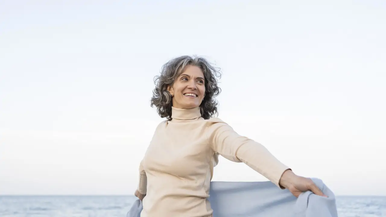 mujer de edad disfrutando de su tiempo en la playa